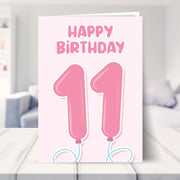 11th birthday card for girls shown in a living room