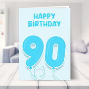 90th birthday card for him shown in a living room