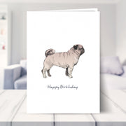 pug birthday card shown in a living room