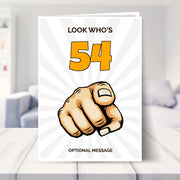 funny 54th birthday card shown in a living room