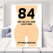 funny 84th birthday card shown in a living room